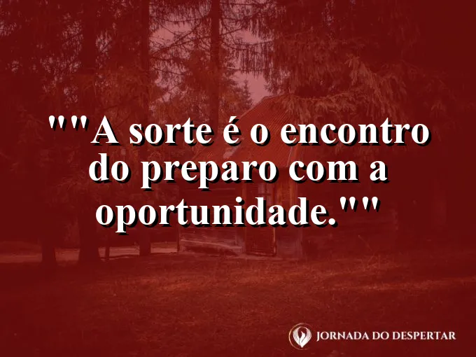 Mão segurando um trevo de quatro folhas sobre uma mesa de estudos.